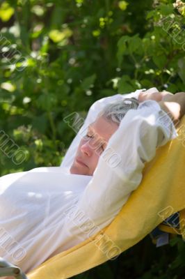 Senior woman sleeping on lounger