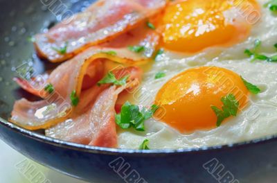 fried egg with bacon in a frying pan