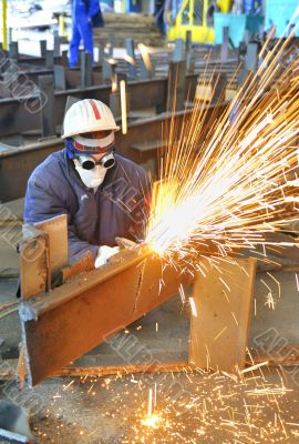 worker using torch cutter to cut through metal