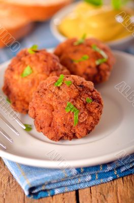 meat balls with mustard on white dish 