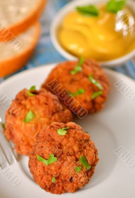 meat balls with mustard on white dish