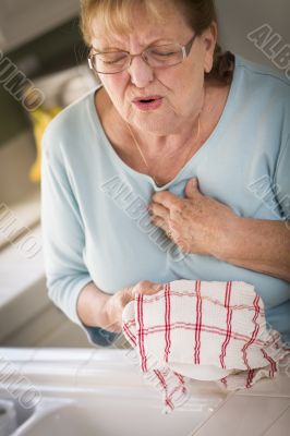 Senior Adult Woman At Sink With Chest Pains