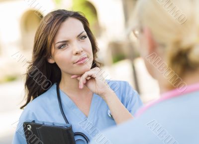Two Young Adult Female Doctors or Nurses Talking Outside Two Young Adult Female Doctors or Nurses Talking Outside