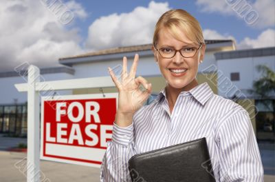 Businesswoman In Front of Office Building and For Lease Sign