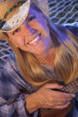 Beautiful Cowgirl Near Campfire Playing Her Ukulele