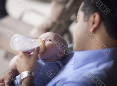 Happy Hispanic Father Bottle Feeding His Mixed Race Son Happy Hispanic Father Bottle Feeding His Mixed Race Son