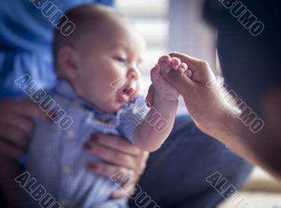 Cute Mixed Race Infant Boy Holds Father`s Thumb