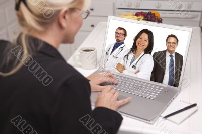 Woman In Kitchen Using Laptop, Online with Nurses or Doctors