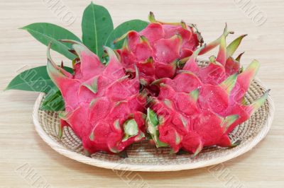 dragon fruits in basket on wooden desk