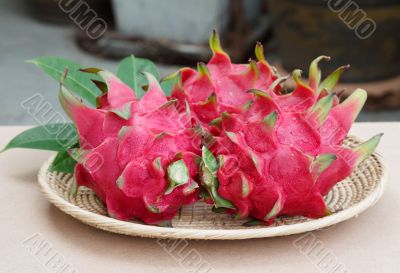 dragon fruits in basket on wooden desk