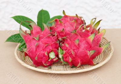 dragon fruits in basket on wooden desk