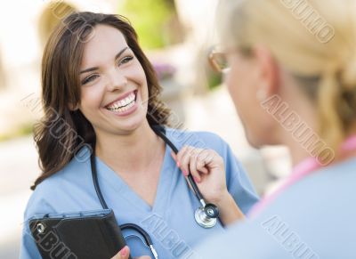 Two Young Adult Female Doctors or Nurses Talking Outside Two Young Adult Female Doctors or Nurses Talking Outside