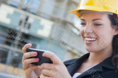 Female Contractor Wearing Hard Hat on Site Texting with Phone