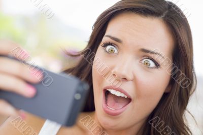 Shocked Young Adult Female Reading Cell Phone Outdoors