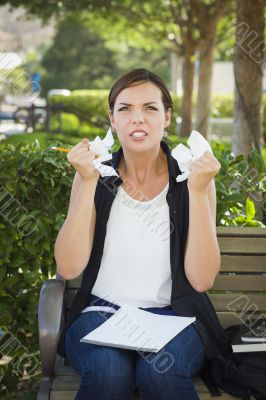 Upset Young Woman with Pencil and Crumpled Paper in Hands