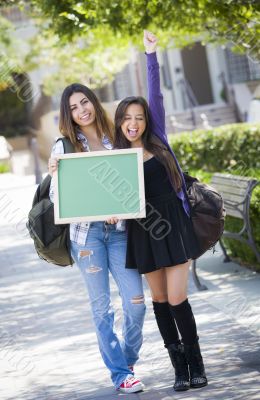 Excited Mixed Race Female Students Holding Blank Chalkboard