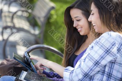 Two Mixed Race Students Using Touch Pad Computer Outside