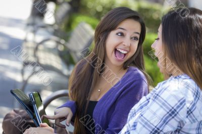 Two Mixed Race Students Using Touch Pad Computer Outside