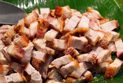 Roast pork cut into pieces on palm leaf
