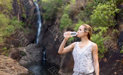 Young healthy woman drinks water from bottle.Outdoor