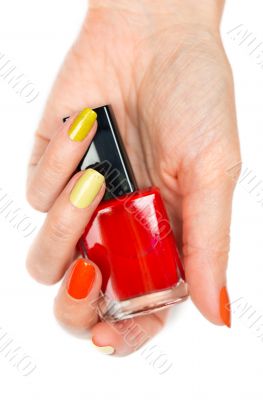 A bottle of red nail polish in a female hand