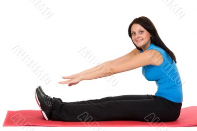 Young beautiful girl sitting on a yoga mat