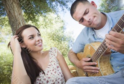 Mixed Race Couple at the Park Playing Guitar and Singing