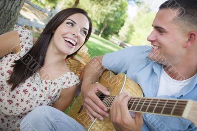 Mixed Race Couple at the Park Playing Guitar and Singing