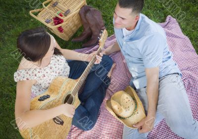 Mixed Race Couple at the Park Playing Guitar and Singing