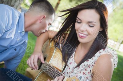 Mixed Race Couple at the Park Playing Guitar and Singing