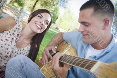 Mixed Race Couple at the Park Playing Guitar and Singing