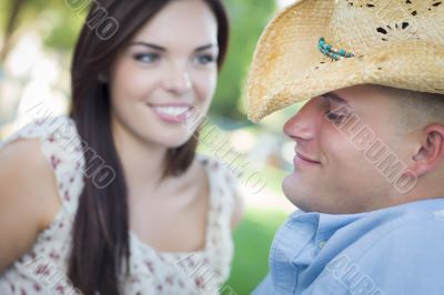 Mixed Race Romantic Couple with Cowboy Hat Flirting in Park Mixed Race Romantic Couple with Cowboy Hat Flirting in Park