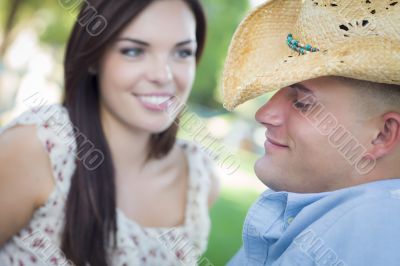 Mixed Race Romantic Couple with Cowboy Hat Flirting in Park