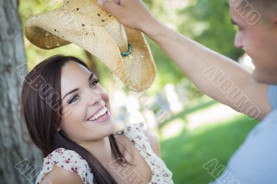 Mixed Race Romantic Couple with Cowboy Hat Flirting in Park