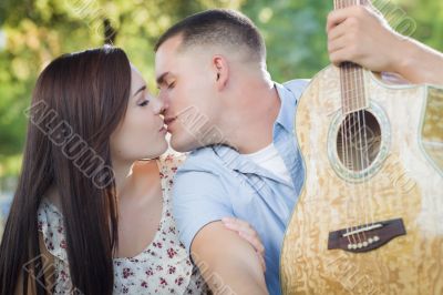 Mixed Race Couple Portrait with Guitar in Park