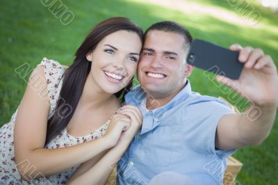 Mixed Race Couple Taking Self Portrait in Park