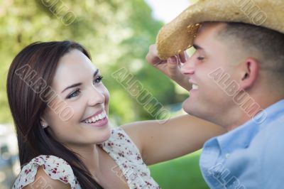 Mixed Race Romantic Couple with Cowboy Hat Flirting in Park