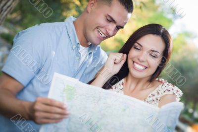 Mixed Race Couple Looking Over Map Outside Together Mixed Race Couple Looking Over Map Outside Together