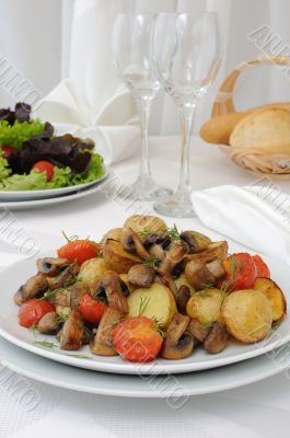 Baked potatoes with slices of mushrooms and tomatoes