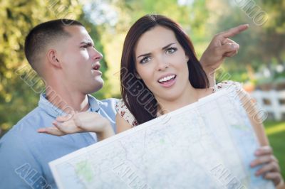 Lost and Confused Mixed Race Couple Looking Over Map Outside