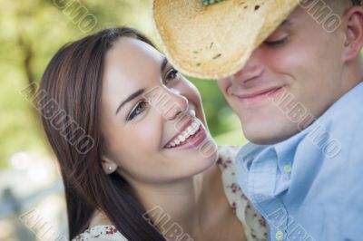 Mixed Race Romantic Couple with Cowboy Hat Flirting in Park