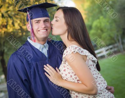 Male Graduate in Cap and Gown and Girl Celebrate Male Graduate in Cap and Gown and Girl Celebrate