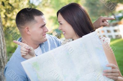 Lost and Confused Mixed Race Couple Looking Over Map Outside