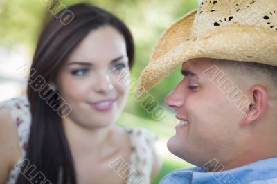 Mixed Race Romantic Couple with Cowboy Hat Flirting in Park