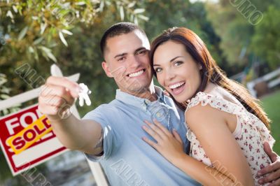 Military Couple with House Keys and Sold Real Estate Sign
