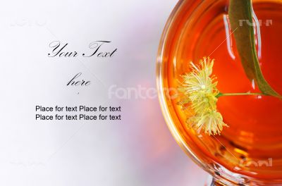 Linden tea in a transparent cup and linden flowers 