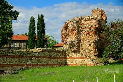 Ancient ruins on the background of modern buildings in the city