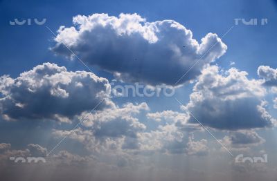 Bright blue sky with puffy white clouds.