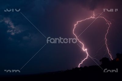 Lightning bolt striking in the sky from clouds