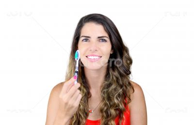 Beautiful young woman showing toothbrush and smiling